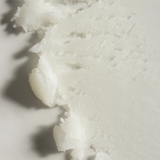 Macro view of Tallow Me Pretty's Creamsicle Organic Lip Balm, showcasing its rich and luxurious texture that promises deep hydration and nourishment for the lips, with a natural tallow-based formula.