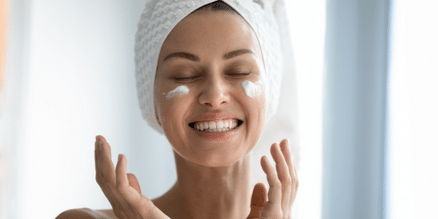 woman smiling with lotion on her face