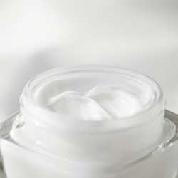 white cream in a clear glass jar