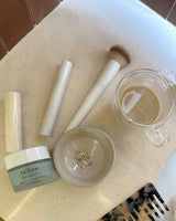 Best tallow face cream: Ageless Cloud Cream, tallow lip balms and a makeup brush on a vanity counter