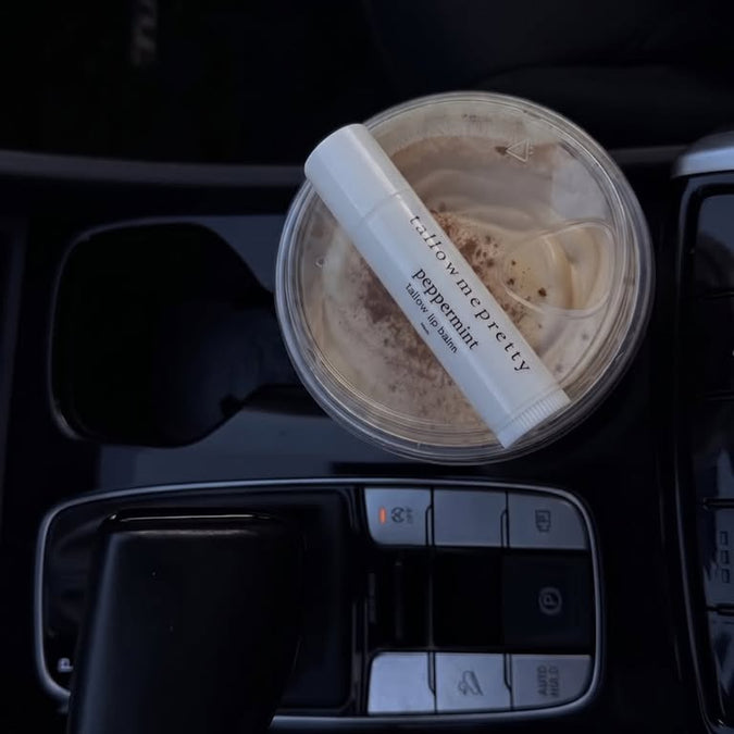 Tallow lipstick: Peppermint tallow lip balm resting on an iced coffee in a car cup holder