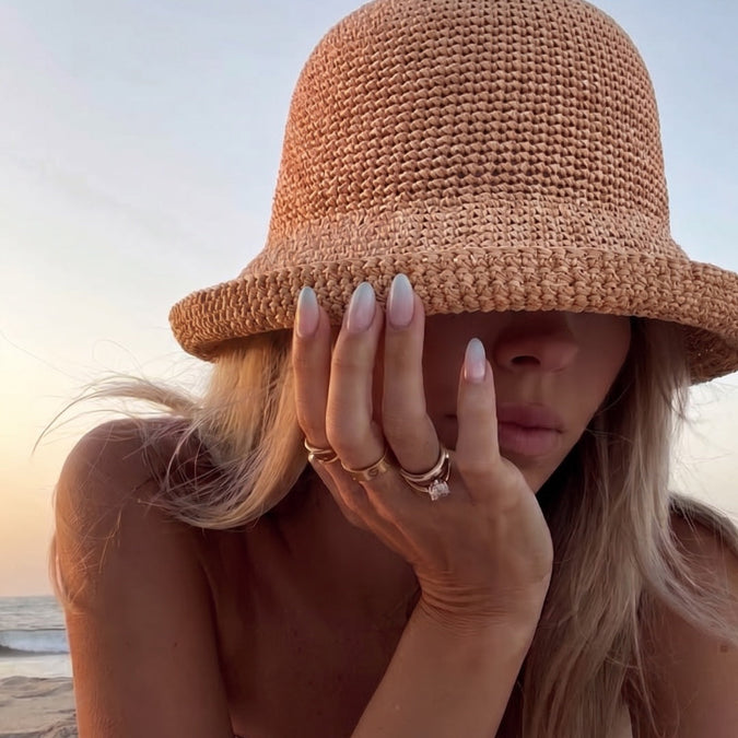 Tallow moisturizer: woman in a straw hat at the beach at sunset