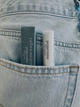 Beef tallow for lips: Peppermint tallow lip balm and its box tucked in a denim pocket