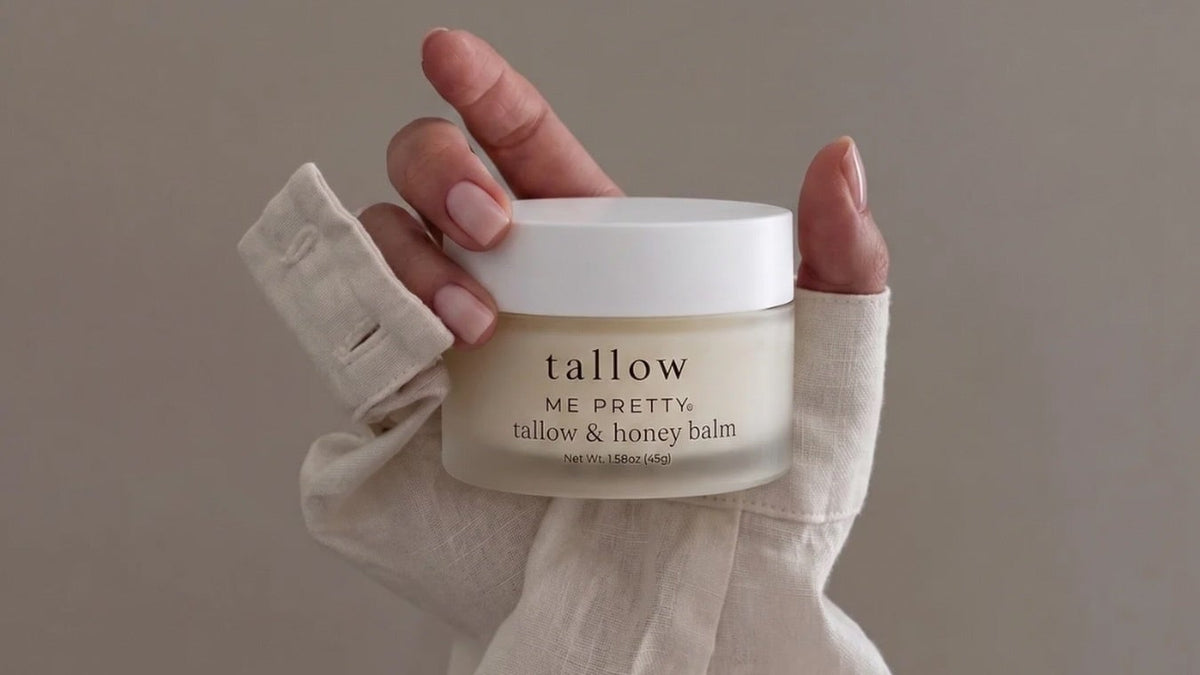 Hand cream with simple ingredients: hand wrapped in linen holding a jar of Tallow and Honey Balm