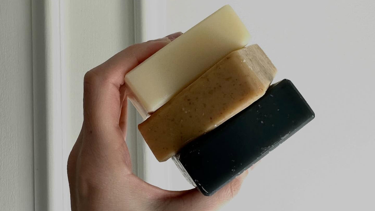 Tallow soap: hand holding a stack of three tallow soap bars