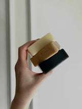 Tallow soap: hand holding a stack of three tallow soap bars