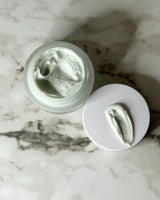 Pretty Farm Girl vs Tallow Me Pretty comparison: open jar of blue green Ageless Cloud Cream with a swipe of cream on the lid