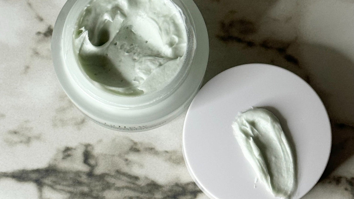 USDA organic grass fed beef tallow skincare: open jar of blue green Ageless Cloud Cream with a swipe of cream on the lid