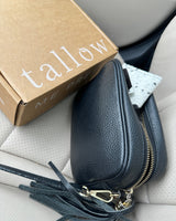 Christmas gift ideas for sister: Tallow Me Pretty shipping box beside a black leather handbag