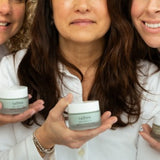 Warm or cold water for wrinkles: three smiling women in white shirts holding jars of Ageless Cloud Cream