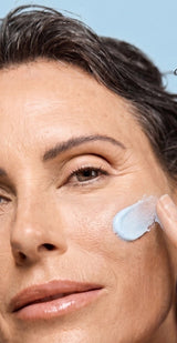 Best anti aging skin care products for your 40s: woman smoothing blue Ageless Cloud Cream onto her cheek