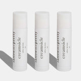 Three tallow lip balms labeled 'creamsicle' on a white background