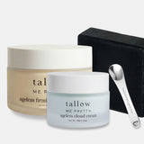 Tallow Me Pretty skincare set featuring an Ageless Firming cream jar, an Ageless Cloud Cream jar, a black bar of soap, and a silver metal scoop on a light gray background.