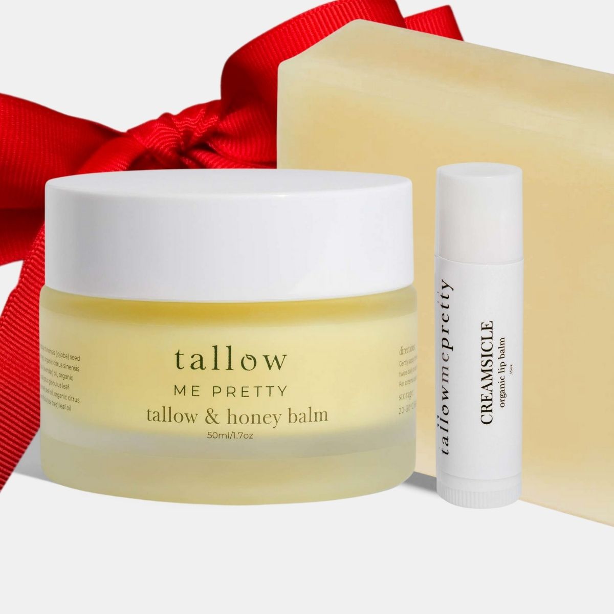 Tallow & Honey balm jar and Creamsicle lip balm with a red ribbon on a white background