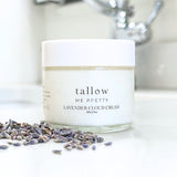 Elegant jar of Tallow Me Pretty Lavender Cloud Cream paired with dried lavender buds on a serene bathroom countertop, illustrating the cream's soothing and moisturizing properties derived from organic lavender.