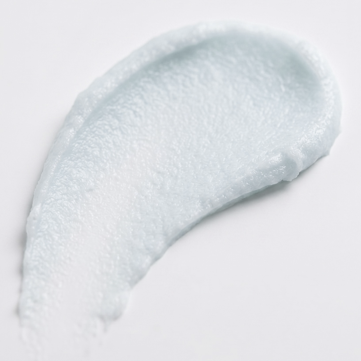 A thick, creamy white cosmetic cream swatch with a fine, bubbly texture on a clean white background.