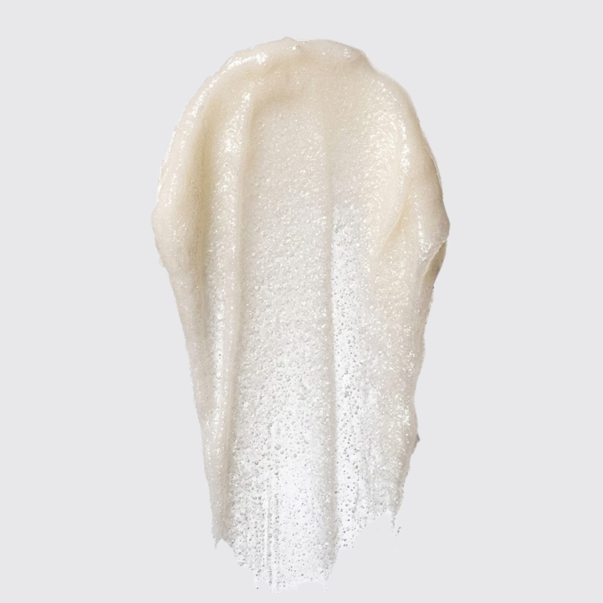 A textured swipe of a creamy, shimmering off-white cosmetic cream or gel on a solid light gray background.
