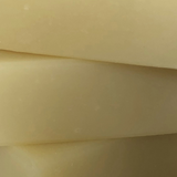 Stacked tallow bars with a creamy, pale yellow hue, displaying a smooth and uniform texture that suggests natural and organic skincare ingredients.