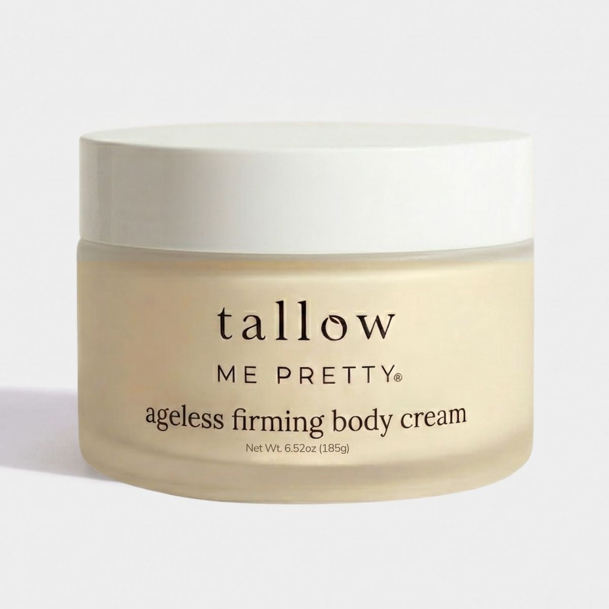 A jar of Tallow Me Pretty Ageless Firming Body Cream on a clean white background. The jar is frosted in a warm cream-beige color, showing the light beige cream inside, and has a solid white lid.