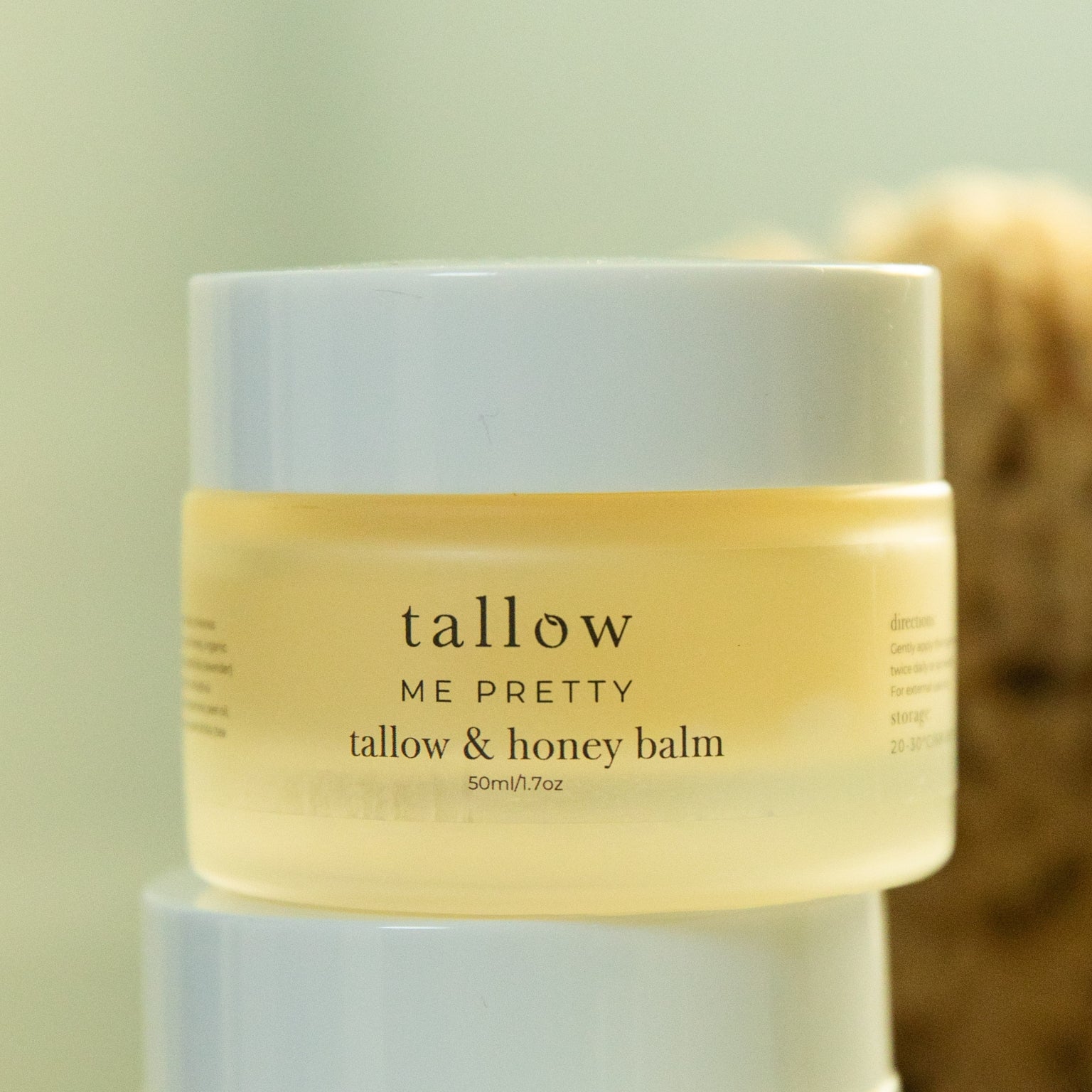 Jar of tallow and honey balm with a blurred background